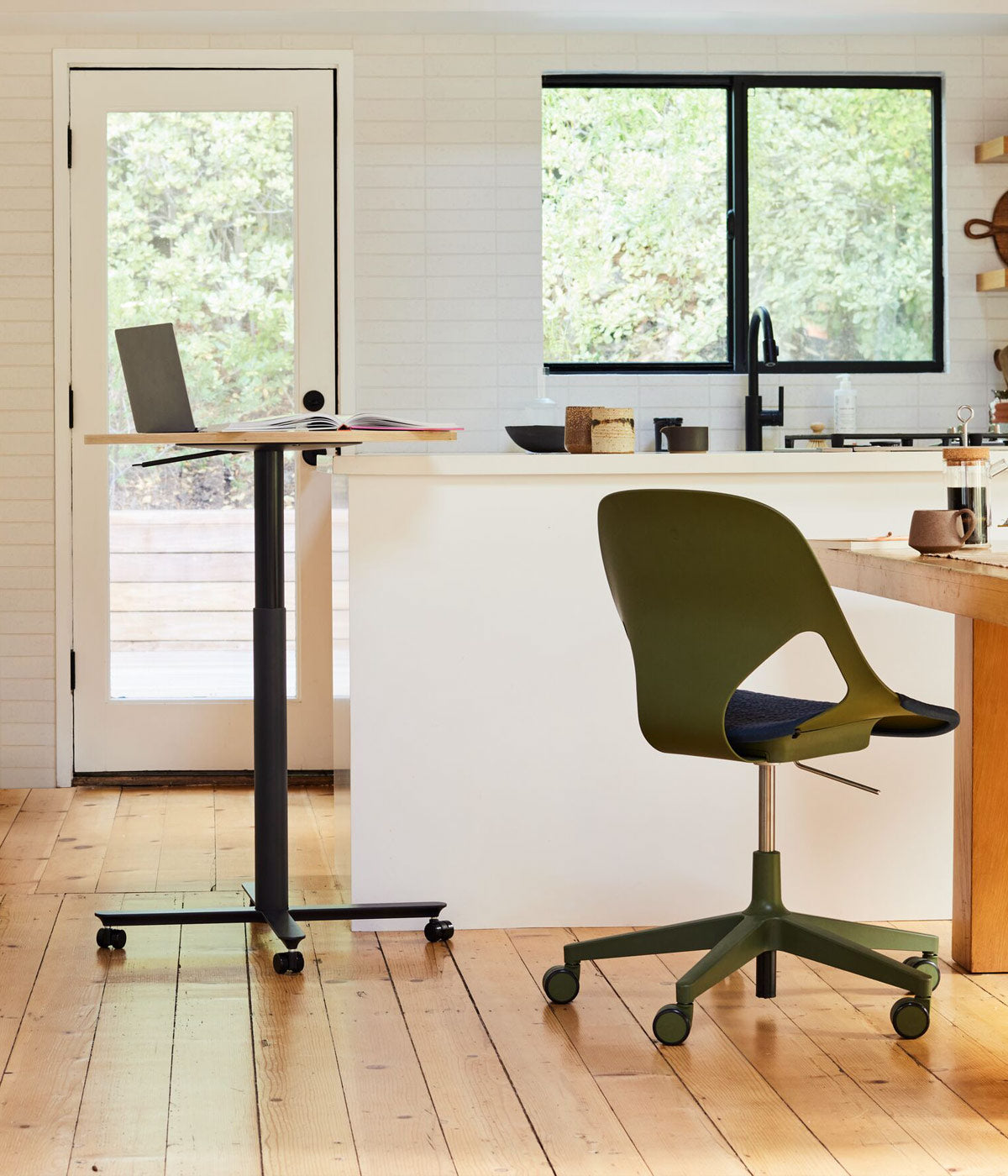 Kitchen home office scene containing Passport sit-stand work table with oak top with a Zeph office chair in olive with nightfall blue seat pad at kitchen table