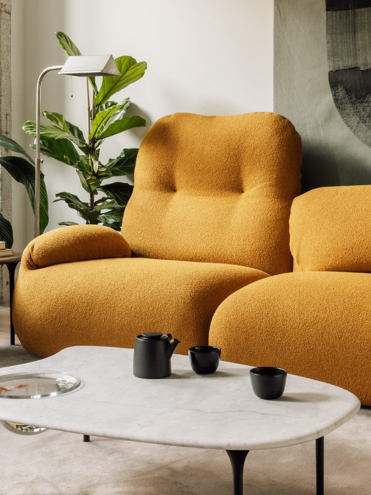A mustard yellow Luva sofa by Herman Miller, showing the sofa back fully upright and folded down.
