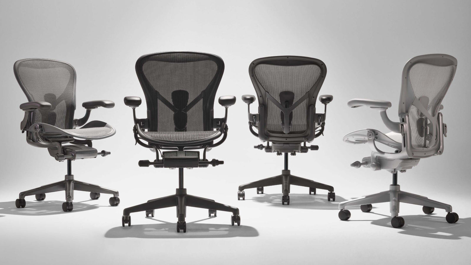 Line up of four Aeron office chairs at different colours including graphite, onyx black, graphite and mineral white