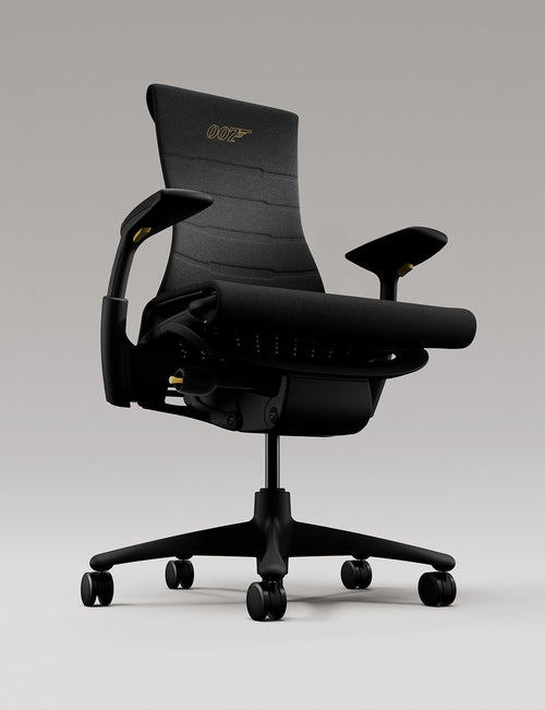 A black Herman Miller Embody Gaming Chair featuring a golden 007 logo in a white studio.