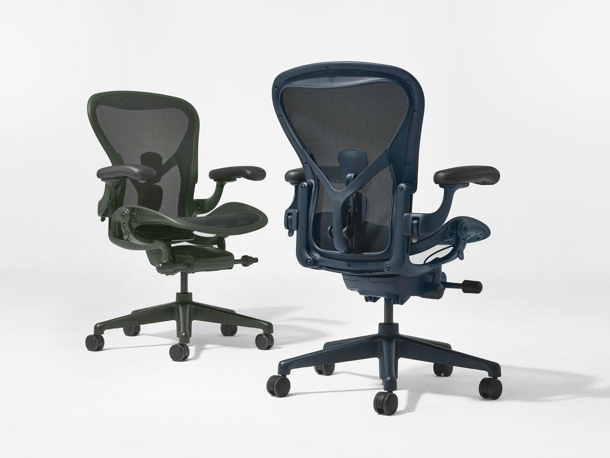 Two Herman Miller Aeron office chairs in Jasper green and Nightfall blue shot in a white studio.