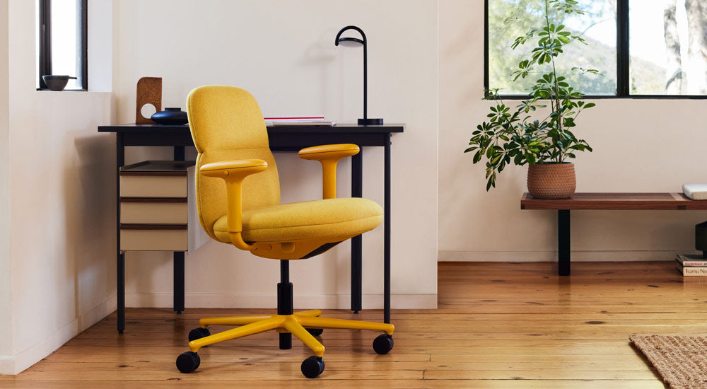 A yellow Asari Chair by Herman Miller, upholstered in Clarion Luce fabric by Maharam - with a Mode Desk and Marselis Lamp
