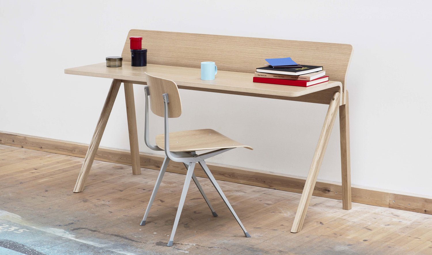 Simple photo of wooden Hay Copenhague 190 desk with chair in front and some accessories on top