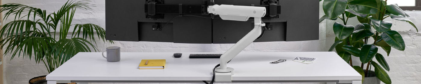 A white Flo X monitor arm holding two monitors.