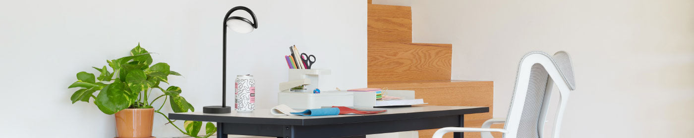 A bright home office with a Herman Miller Mode desk, Cosm ergonomic chair, Marselis lamp and a plant.