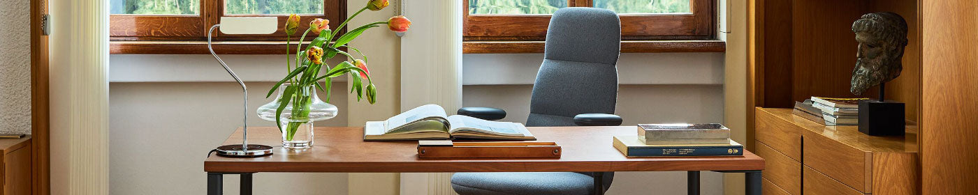 A traditional home office featuring a Herman Miller Asari ergonomic chair sat behind a natural wood topped OE1 desk.
