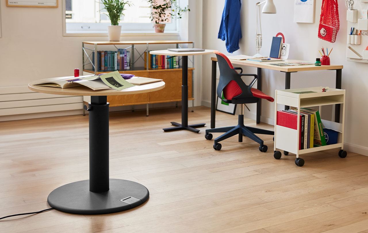 A black and light acacia OE1 Standing Desk, with a Passport Table, Zeph Chair and OE1 Desk in the background.