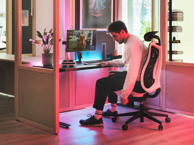 A gaming setup featuring a Herman Miller Vantum in Polar White, alongside a Nevi gaming desk and Ollin monitor arm.