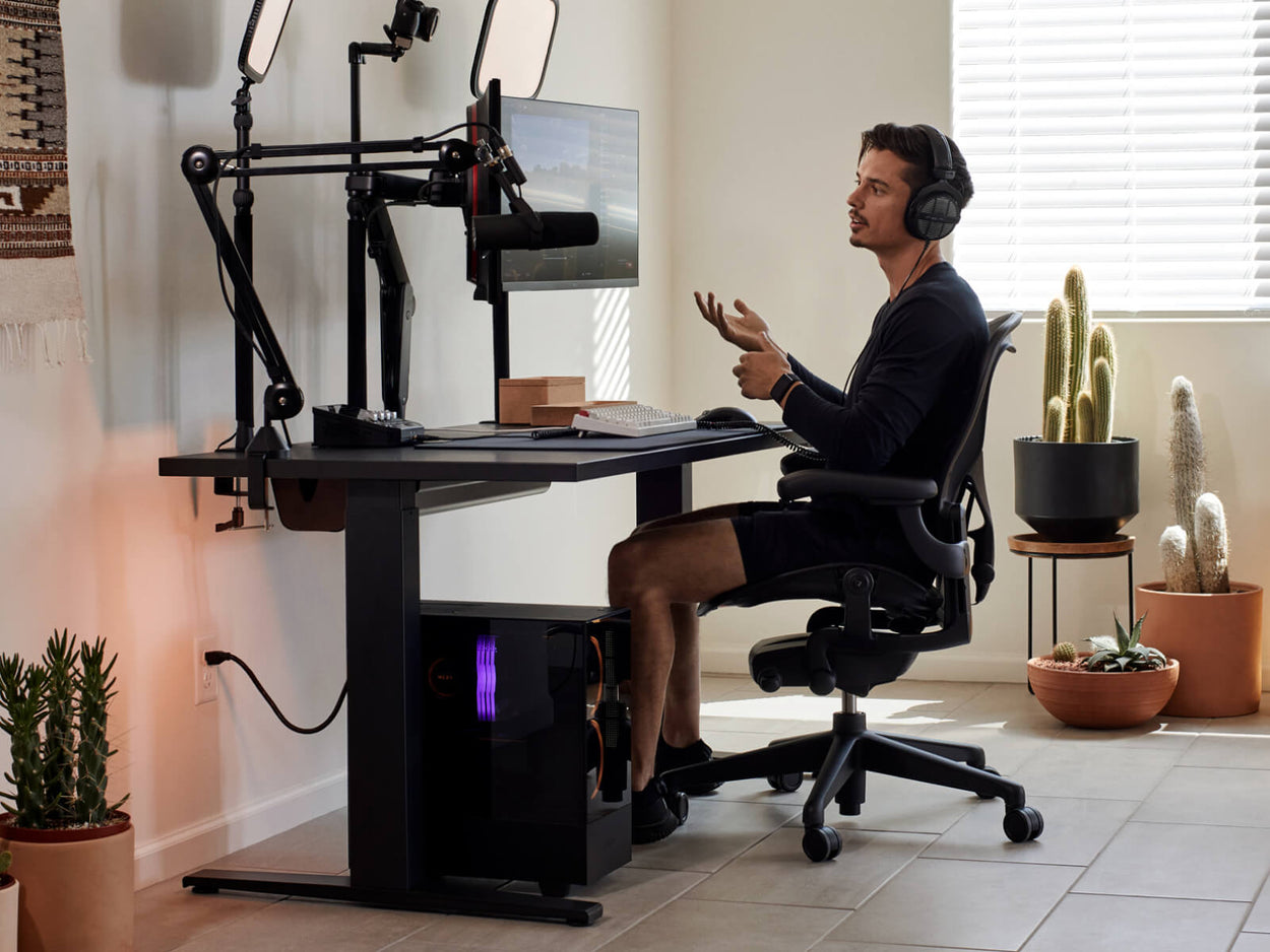 Gamer Xaryu sat at his home gaming set with on Aeron gaming chair graphite with Nevi gaming desk and Ollin dual monitor arms